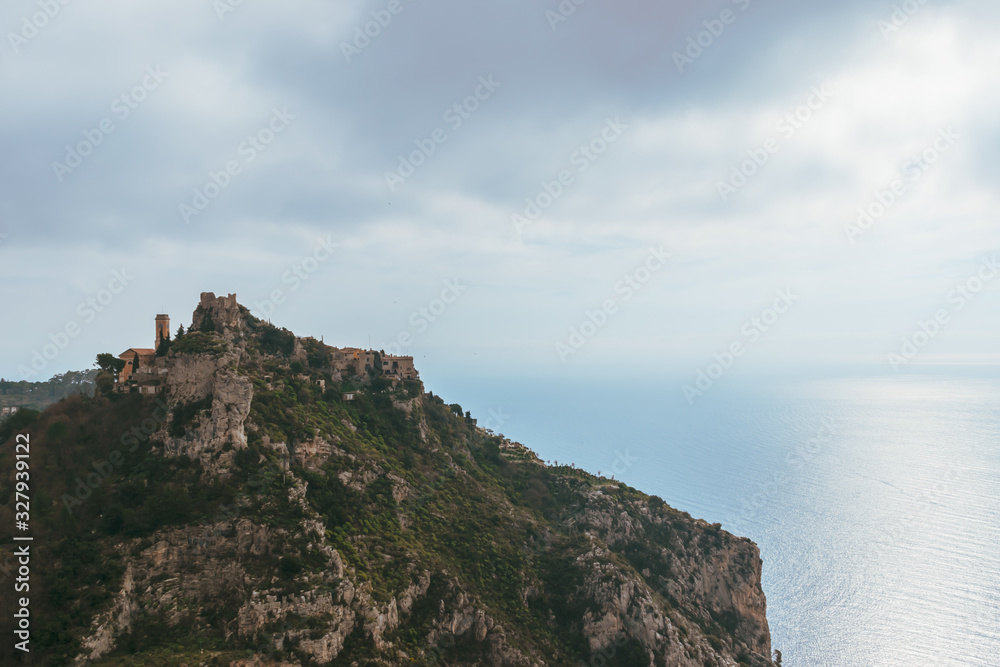 The panoramic view of a medieval fortified castle of an old French village named Èze on top of a cliff and the Mediterranean sea
