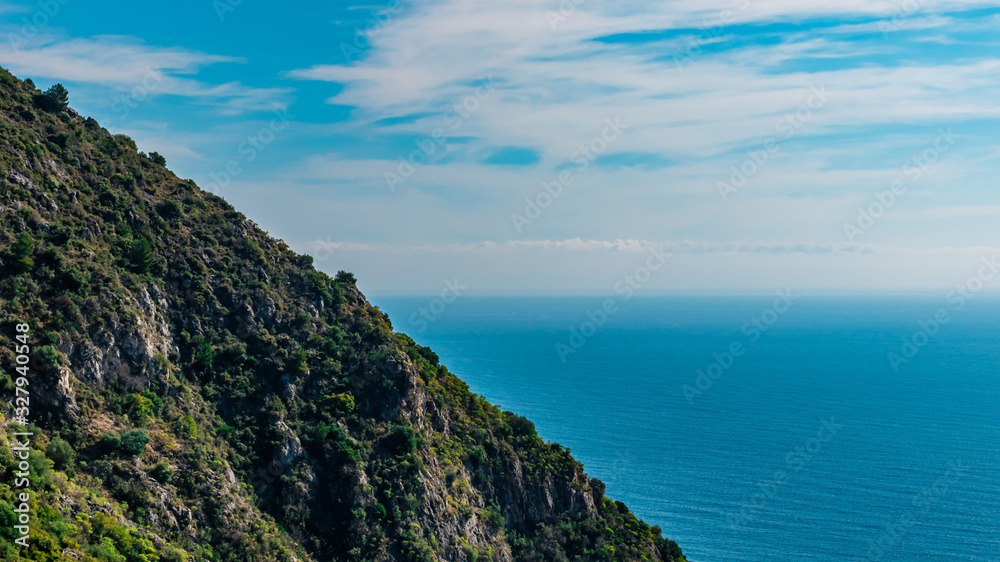 The panoramic view of the Mediterranean Sea's turquoise water and the Alps mountains cliffs on a sunny day (Provence Côte d'Azur, France)