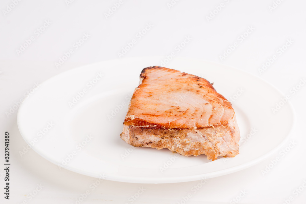 grilled tuna fish steak on a white plate with a place for garnish grilled tuna fish steak on a white plate with a place for garnish