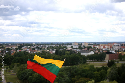 The Lithuanian flag is waving in tricolor over the city photo