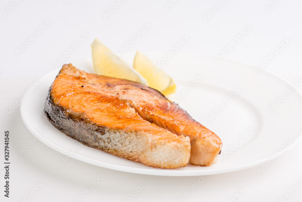 grilled salmon fish steak on a white plate with a place for garnish grilled salmon fish steak on a white plate with a place for garnish