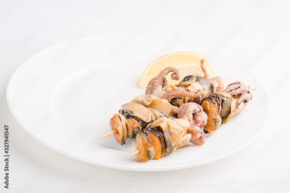 grilled seafood on a skewer on a white plate grilled seafood on a skewer on a white plate