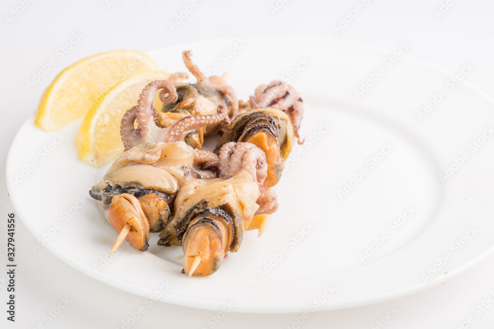 grilled seafood on a skewer on a white plate grilled seafood on a skewer on a white plate