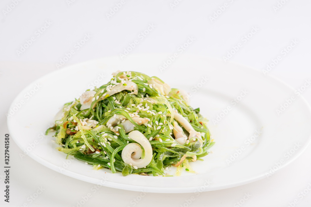 chuka seaweed salad with seafood and sesame seeds on a white plate