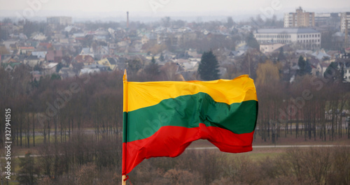 The Lithuanian flag is waving in tricolor over the city photo