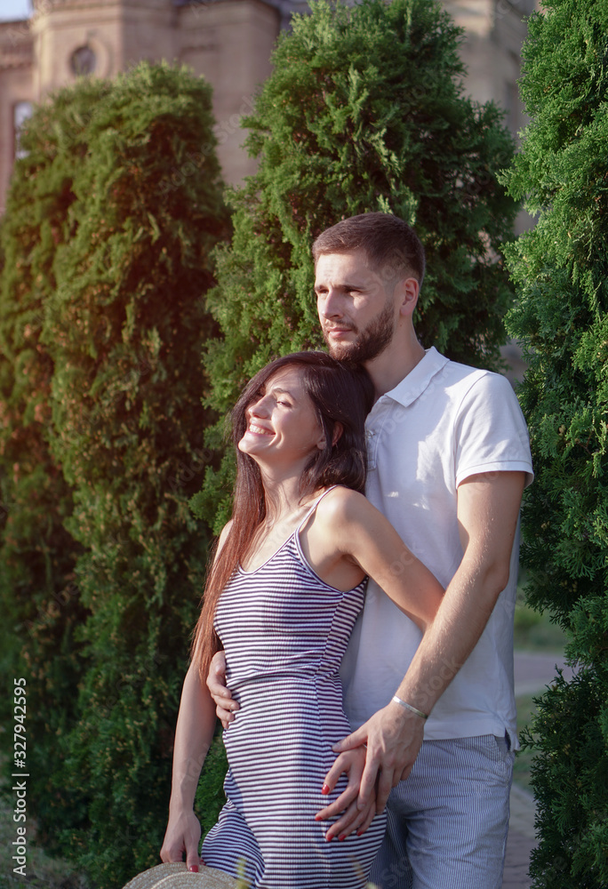 Beautiful couple of man and woman against the backdrop of a beautiful park and city architecture. Romantic theme with a girl and a guy. Spring Summer Temma relationship, love, Valentine's day Beautiful couple of man and woman against the backdrop of a beautiful park and city architecture. Romantic theme with a girl and a guy. Spring Summer Temma relationship, love, Valentine's day