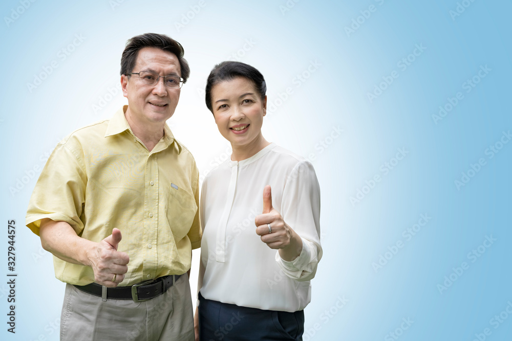 Older couples raise their thumbs to show confidence in their health, isolated on blue background with clipping path. Older couples raise their thumbs to show confidence in their health, isolated on blue background with clipping path.