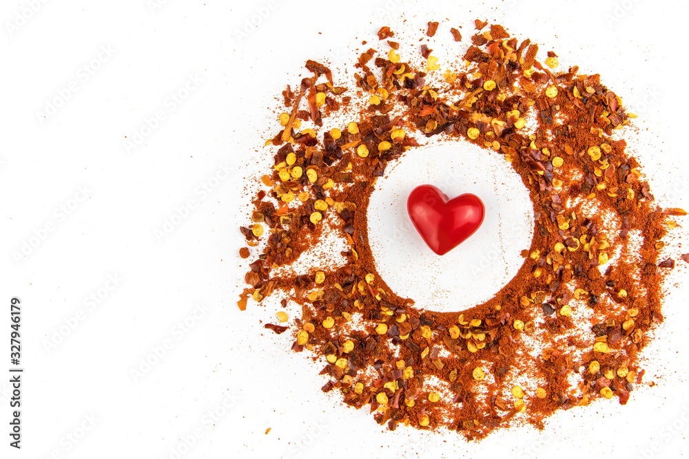 Hot spice. Chilli powder. Dried chili. Healthy spices. Spilled chili on white background.