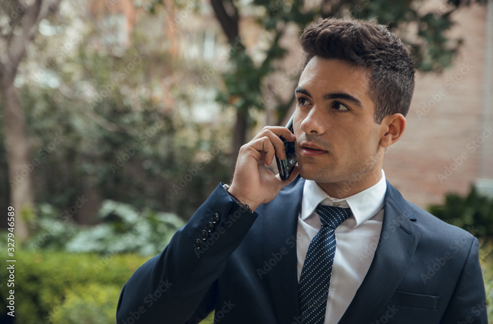 Close up boy in suit calling with phone and walking in park Close up boy in suit calling with phone and walking in park