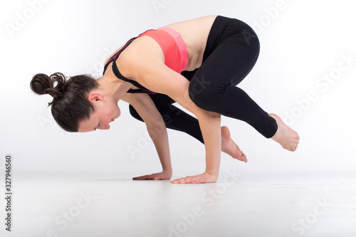 woman in leggings and sports bra is stretching and practicing yoga