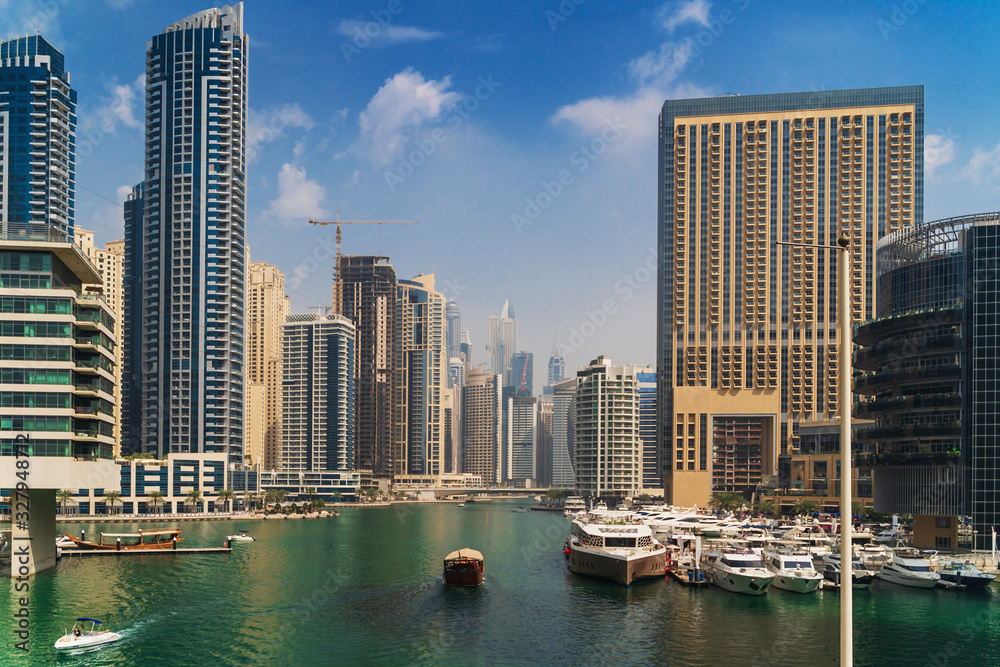 Luxury Dubai Marina canal in summer day with high buildings at background, UAE emirates.