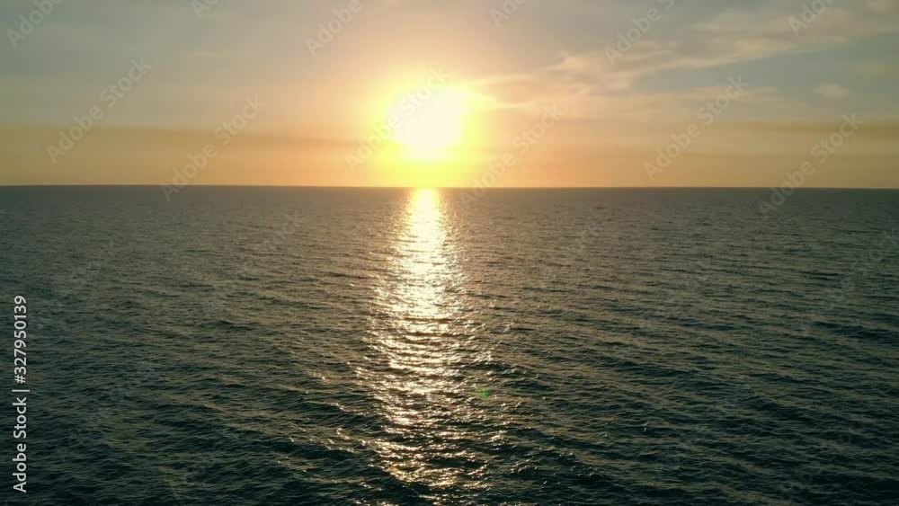 AERIAL: Golden reflections on sea water surface at sunset, aerial video, drone point of view, drone flying above the sea surface. Sea surface with reflections of sunset. Camera moves back over water. AERIAL: Golden reflections on sea water surface at sunset, aerial video, drone point of view, drone flying above the sea surface. Sea surface with reflections of sunset. Camera moves back over water.
