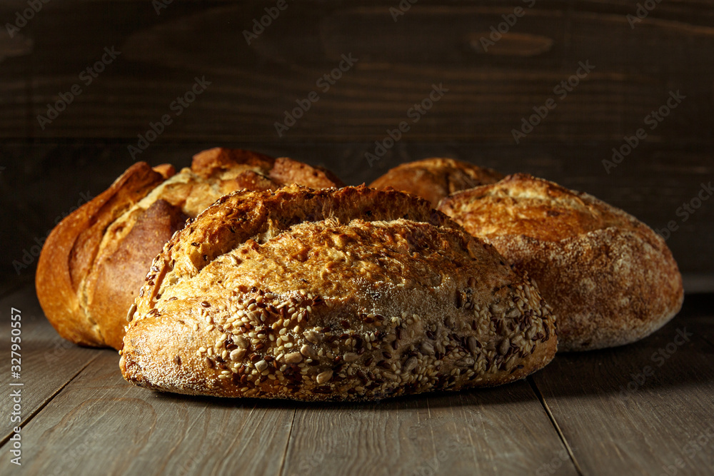 Freshly baked traditional bread on wooden table, with copy space, food closeup. Whole grain rye bread with seeds Freshly baked traditional bread on wooden table, with copy space, food closeup. Whole grain rye bread with seeds
