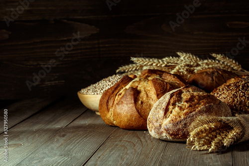 Freshly baked traditional bread on wooden table, with copy space, food closeup. Whole grain rye bread with seeds