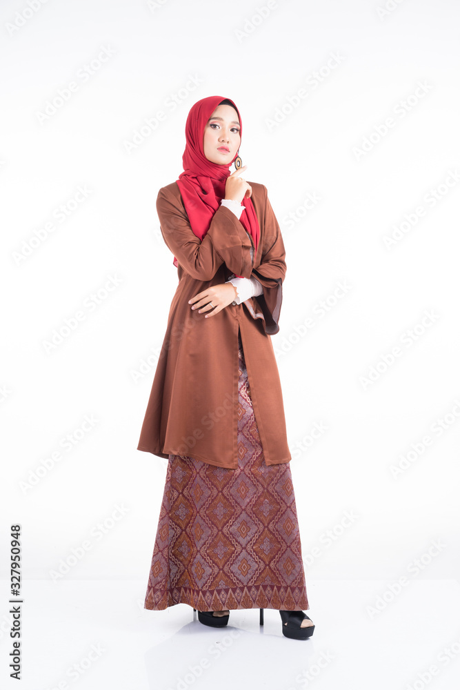 Full length portrait of a beautiful female model wearing a modern kebaya dress and hijab, a lifestyle apparel for Muslim women isolated on white background. Beauty and hijab fashion concept.
