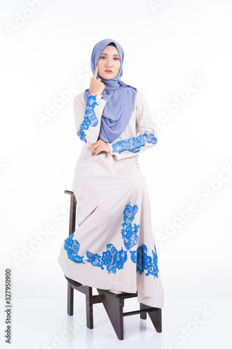 Full length portrait of a beautiful female model wearing jubah dress and hijab, a lifestyle apparel for Muslim women isolated on white background. Beauty and hijab fashion concept. photo