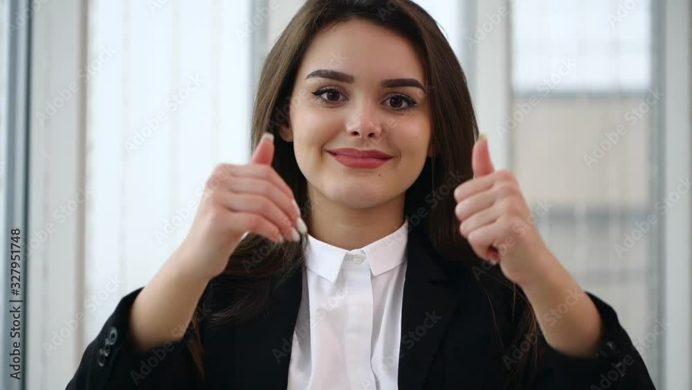 Business woman smiling for camera with her thumb fingers up, isolated on white panoramic background. Close up. Copy space. Slow motion. 4K. Business woman smiling for camera with her thumb fingers up, isolated on white panoramic background. Close up. Copy space. Slow motion. 4K.