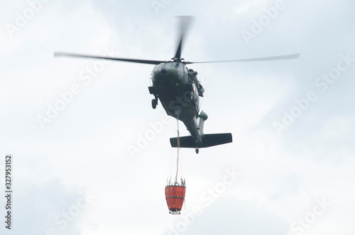 Sikorsky UH-60 Black Hawk helicopter with bambI bucket landing military base