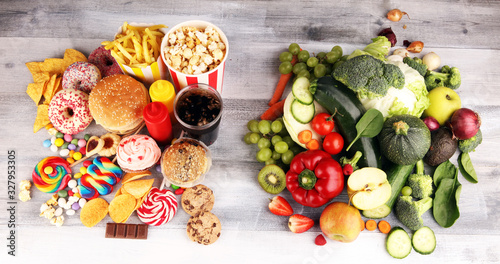 Fototapeta Naklejka Na Ścianę i Meble -  healthy or unhealthy food. Concept photo of healthy and unhealthy food. Fruits and vegetables vs donuts,sweets and burgers