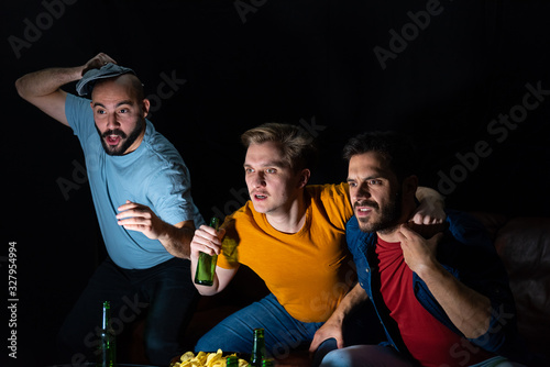 Group of friends watching sport game at home, cheering