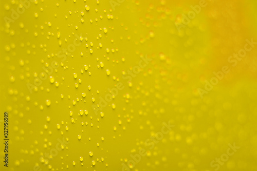 soft focus water drops on vivid yellow perspective surface wallpaper background concept 