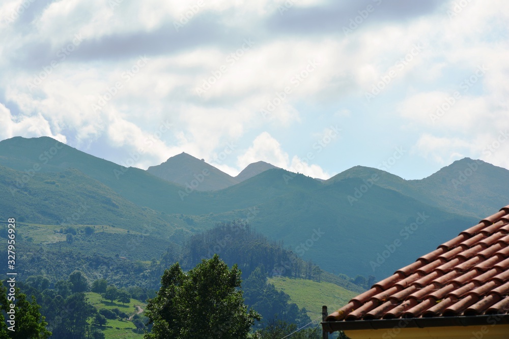 red roof and landscape of mountains against blue sky red roof and landscape of mountains against blue sky