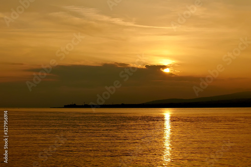 A beautiful sunset at sea in orange tones with seagulls and a sea vessel. Russia s Black Sea coast