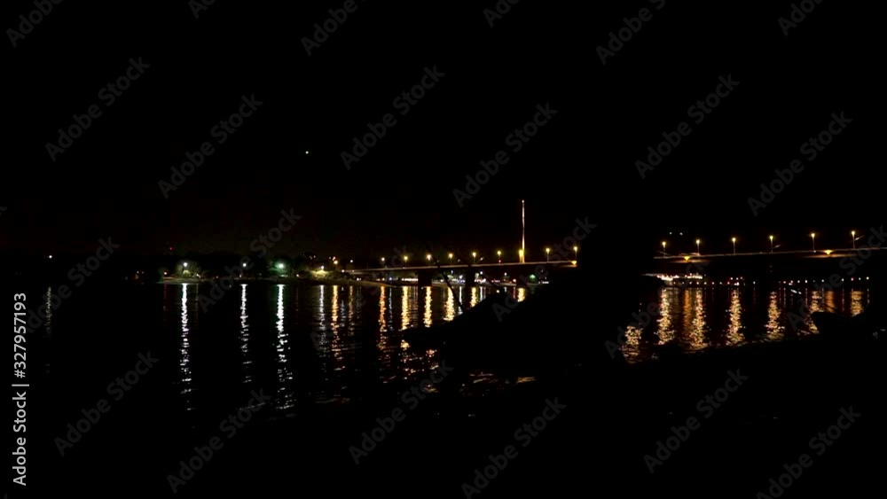 Silhouette of a angler sitting in chair on a river shore, waiting for fish Silhouette of a angler sitting in chair on a river shore, waiting for fish