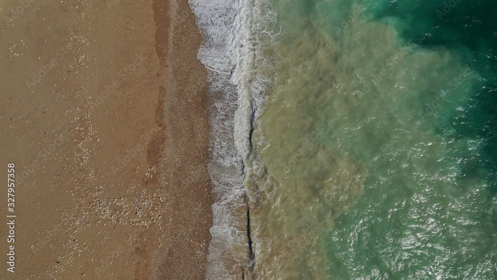 Aerial drone top view photo of emerald waves reaching sandy open ocean shore