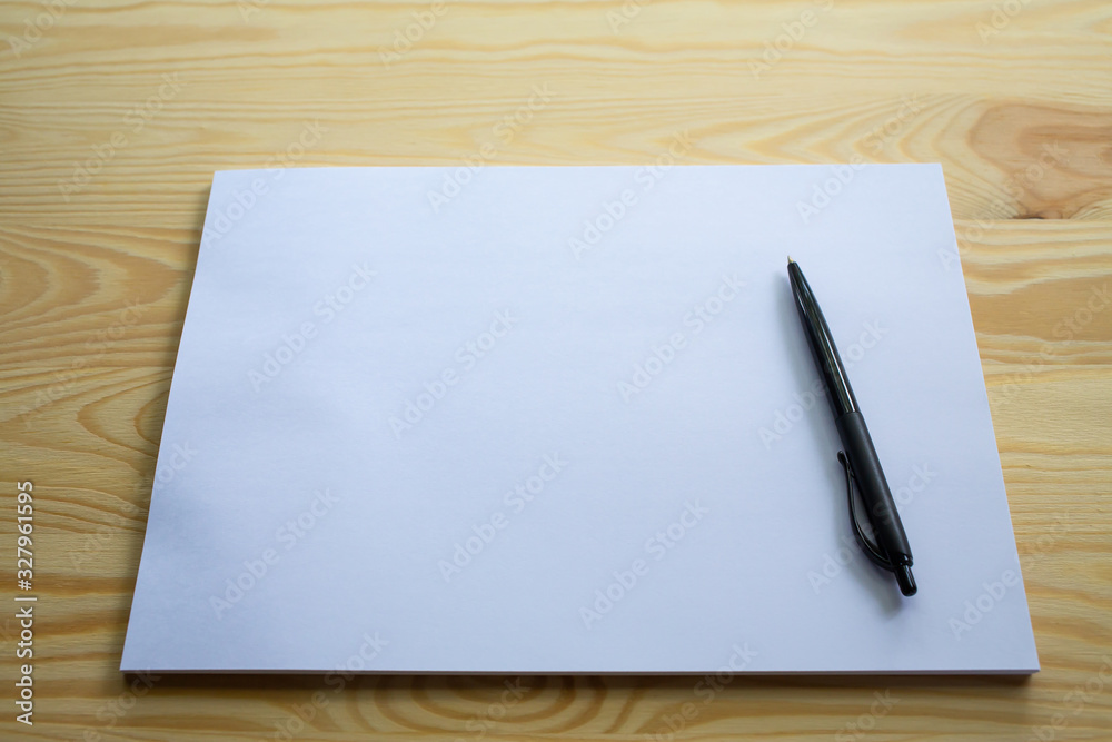 White papers size A4 with a black pen on wood table texture background, Brainstorming, Creative idea, Business concept White papers size A4 with a black pen on wood table texture background, Brainstorming, Creative idea, Business concept