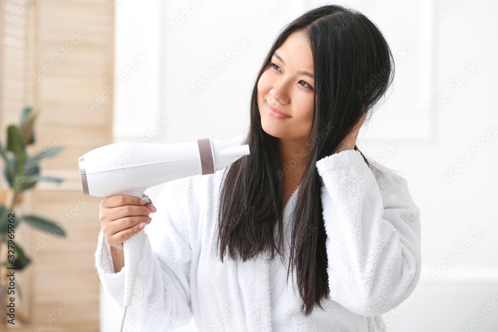 Beautiful Asian woman with hair dryer at home Beautiful Asian woman with hair dryer at home