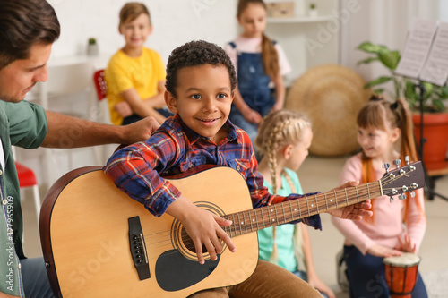 Teacher giving music lessons at school photo