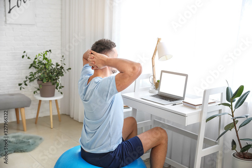 Man sitting on fitness ball...