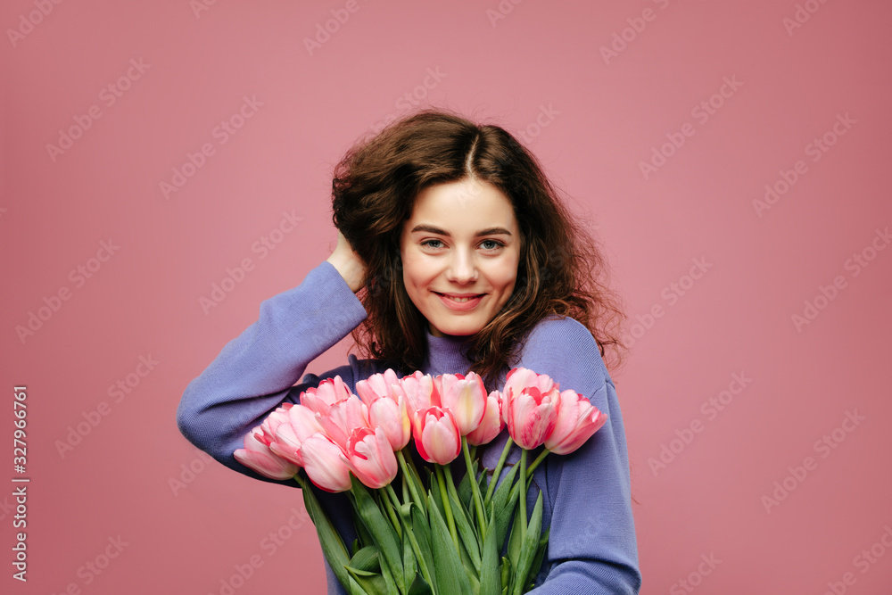 Girl holding bouquet of spring flower tulips against pink background. International womans day Girl holding bouquet of spring flower tulips against pink background. International womans day