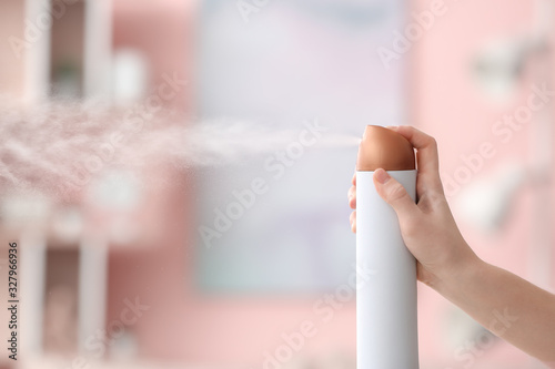 Woman spraying air freshene...