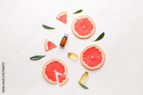 Composition with grapefruit essential oil on white background