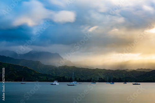 sailboats at Hanalie Bay beach, Kauai, Hawaii at sunset with mountains in the background © meghann
