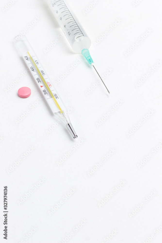 Thermometer and  syringe on white. Medical concepts and medicines