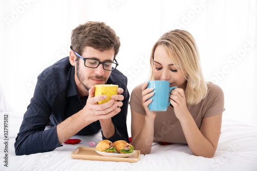 Lovely caucasian couple enjoy having a breakfast and black coffee together.