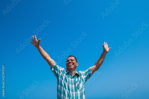 A happy man with his arms in the air in a park. Retired concept © Hector Pertuz