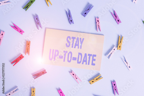 Conceptual hand writing showing Stay Up To Date. Concept meaning knows all the most recent news and changes in a situation Colored clothespin rectangle shaped paper blue background photo