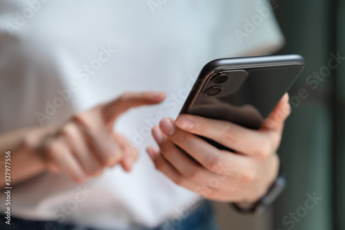 woman holding and using smartphone typing sms message at social network.
