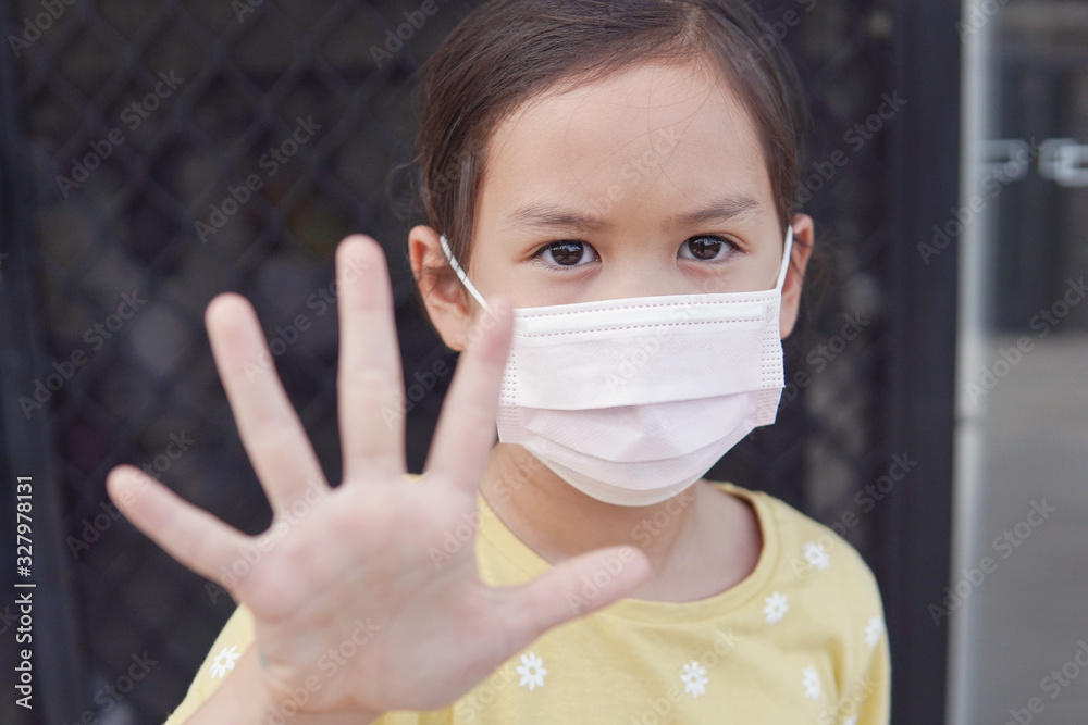 Asian little girl wearing medical face mask and making stop sign, coronavirus, covid-19  virus, pm 2.5 air pollution and health, stop Asian hate concept