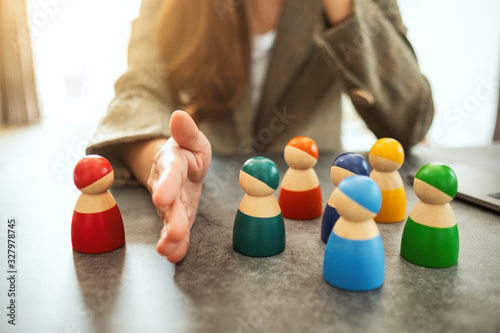 Bilde på lerret Concept image of a business woman separate one wooden people from a group