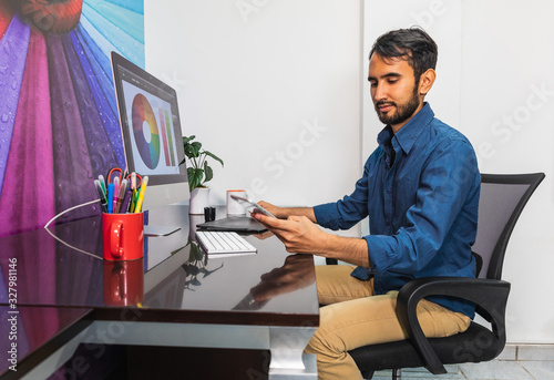 Side view. Young bearded businessman sitting in office