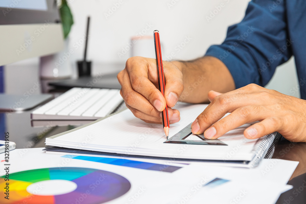 Close up view. Man drawing sketch. On table color swatch and stationery. Man drawing sketch Close up view. Man drawing sketch. On table color swatch and stationery. Man drawing sketch