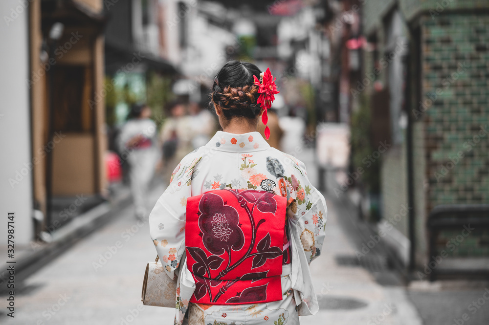 Fototapeta premium Young women wearing traditional Japanese Kimono with colorful maple trees in autumn is famous in autumn color leaves and cherry blossom in spring, Kyoto, Japan.