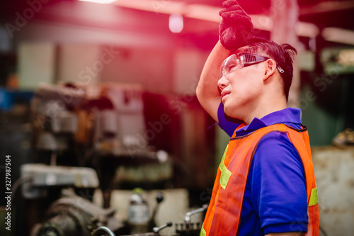 Tired worker, headache hot weather over heat unhealthy engineer working in heavy industry factory. photo