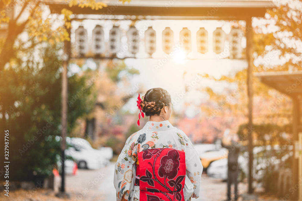  Young women wearing traditional Japanese Kimono with colorful maple trees in autumn is famous in autumn color leaves and cherry blossom in spring, Kyoto, Japan.