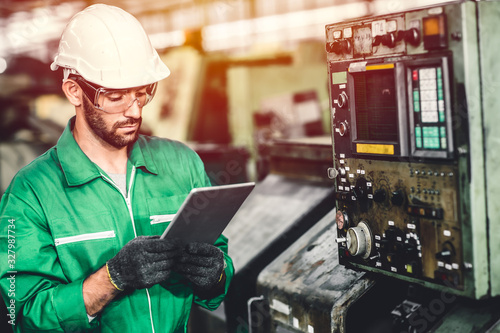 Obraz na płótnie Green eco worker checking energy consumption engieer working in heavy industry factory with green colour safety suit